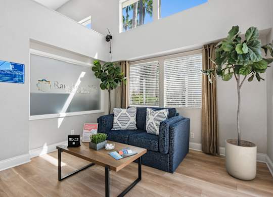 A living room with a blue couch and a wooden coffee table.
