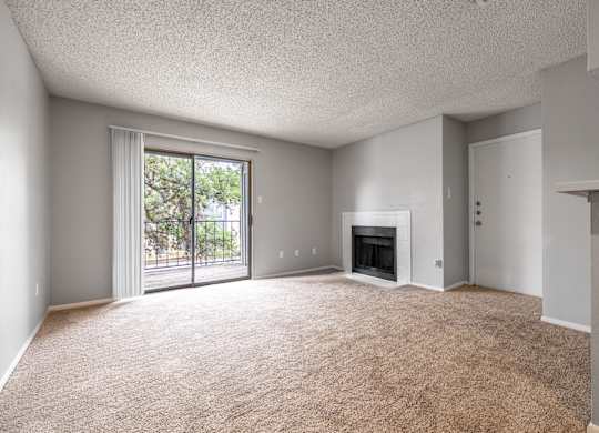 A spacious living room with a fireplace and sliding glass doors.