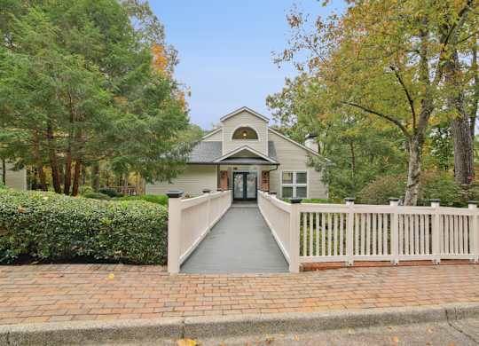 A house with a grey front door and a white fence.