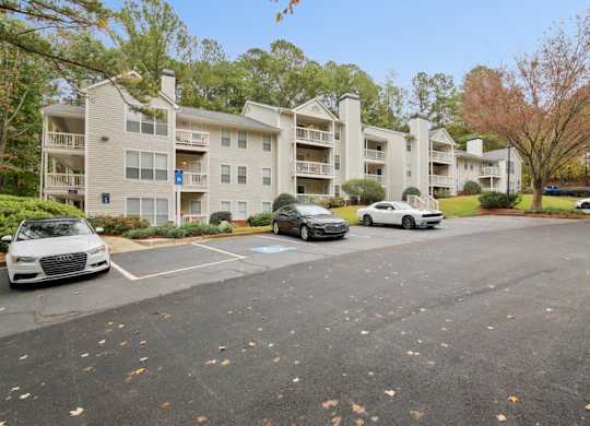 A parking lot with cars and apartment buildings in the background.