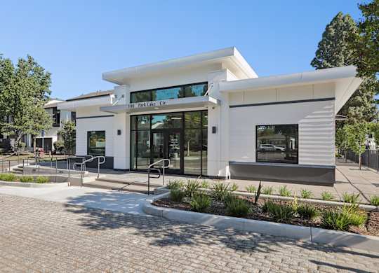 A white building with a glass entrance and a sign that reads