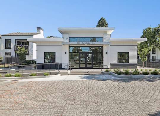 A white building with a black gate in front.
