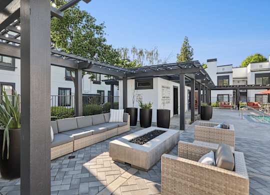 A patio area with a fire pit and seating.