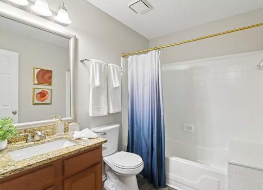 A bathroom with a toilet, sink, and shower.