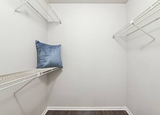 A white closet with a pillow on a shelf.