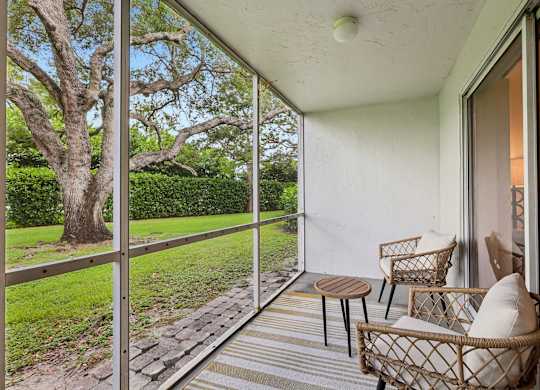 A patio with a table and chairs overlooking a garden.