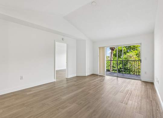 A room with wooden flooring and white walls.