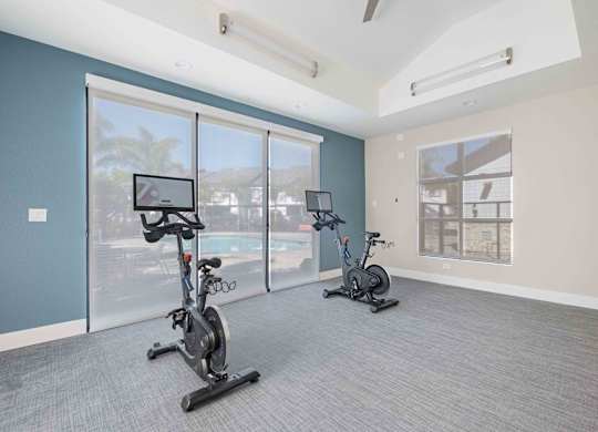 A room with exercise bikes and a view of the outside.
