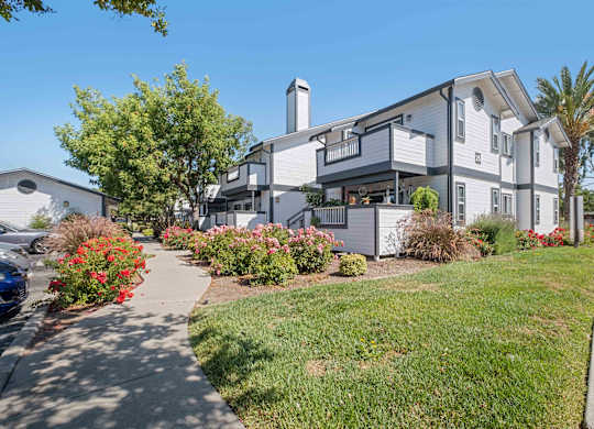 A modern two-story house with a balcony and a chimney.