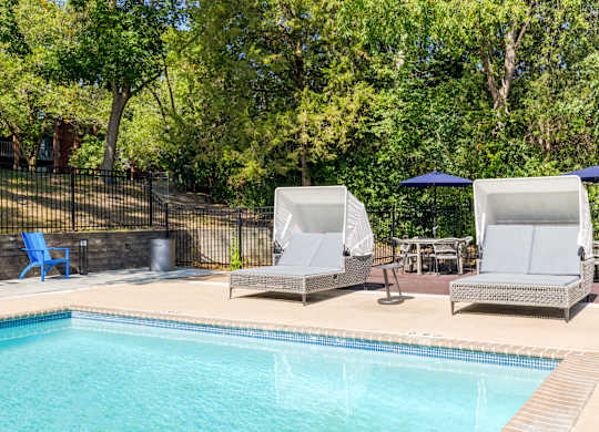 Two sun loungers sit on the edge of a pool.