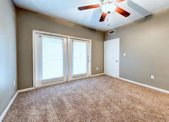 Bedroom with balcony doors and ceiling fan