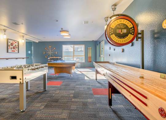 a game room with a pool table and shuffleboard