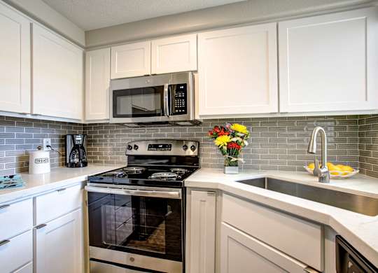 Apartments in Phoenix, AZ - Village at Lakewood Fully Equipped Kitchen with Stainless Steel Appliances and White Cabinetry