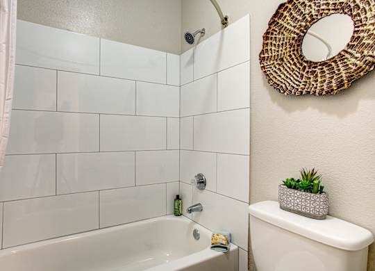 Apartments for Rent in South Phoenix - Village at Lakewood - Bathroom with Bathtub, Circle Mirror, and White Tiles