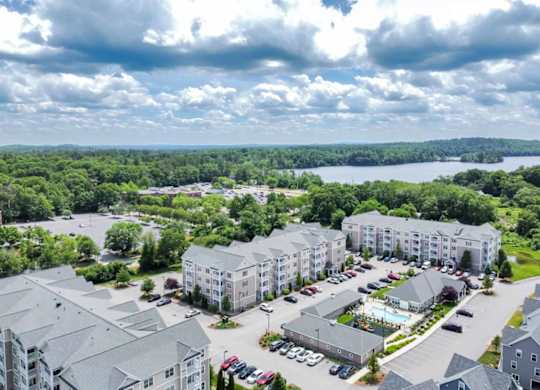 an aerial view of an apartment complex with a lake in the background