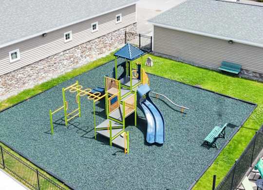 a playground with a slide and monkey bars in a backyard