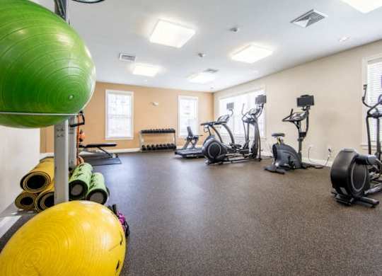 a gym with exercise equipment and weights on the floor