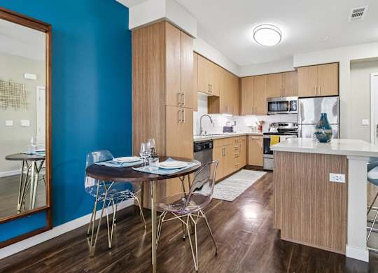 A kitchen with a table and chairs in front of a blue wall.