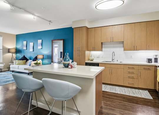 A kitchen with a blue wall and wooden cabinets.
