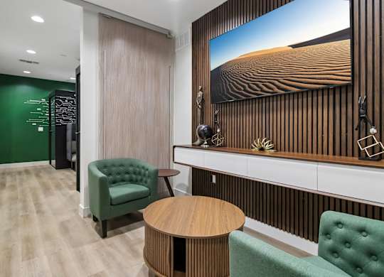 A room with a green chair and a wooden table.