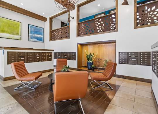 A modern living room with orange chairs and a wooden table.