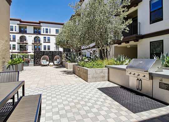 A patio with a grill and a table.