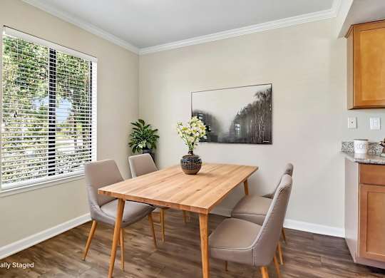 A dining room with a wooden table and chairs.