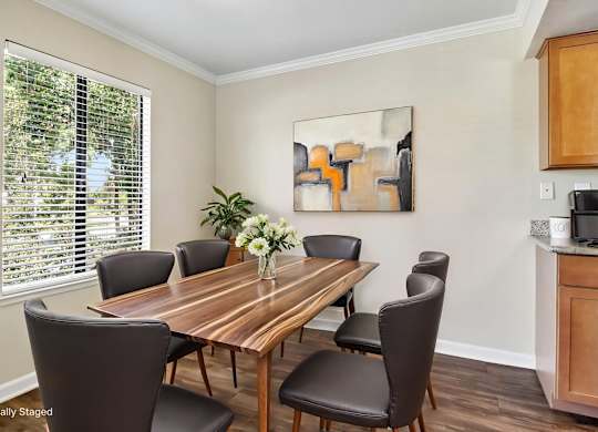 A dining room with a wooden table and chairs.