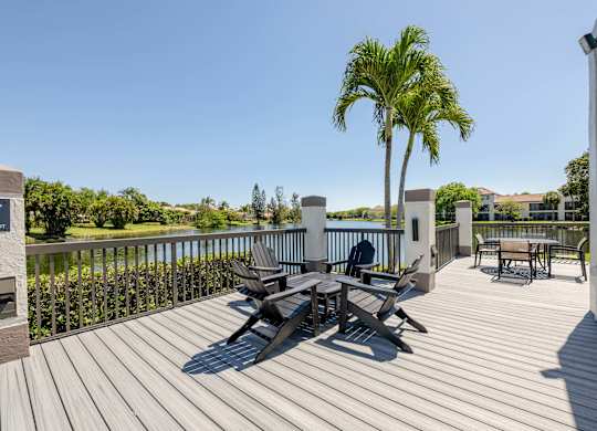 Coconut Creek Apartments – Waterview at Coconut Creek – deck has a palm tree and chairs on it