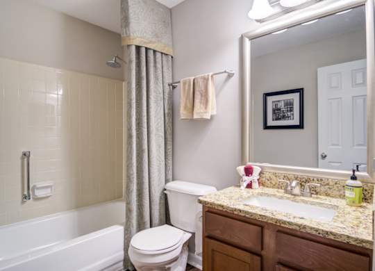 West Marietta, GA Apartments – Wood Pointe Apartments – A bathroom with a toilet, sink, and bathtub.