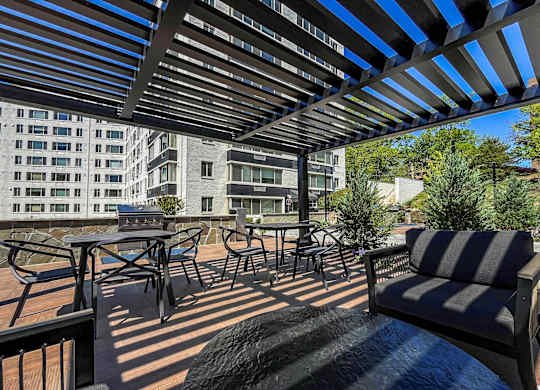 A patio with a striped couch and a table with chairs.