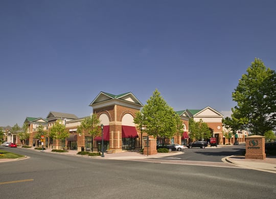 a city street with a building in the foreground and a blue sky in the background at The Residences at King Farm, Maryland, 20850