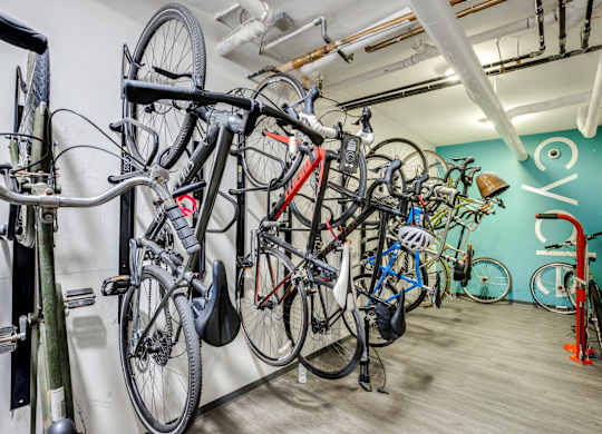 A bike rack with many bikes hanging on it.