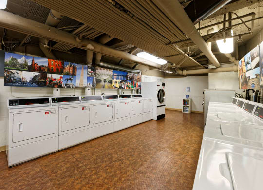 a laundry room with white washers and dryers