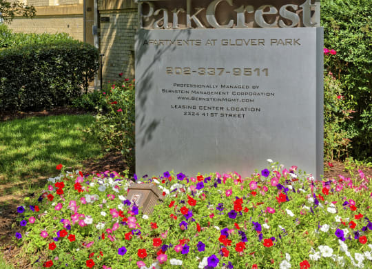 a sign in front of a building with flowers at Park Crest Apartments, Washington, DC