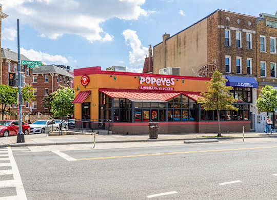 A Popeyes restaurant is located on a corner of a street.