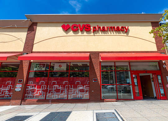 A CVS Pharmacy store with a red awning and glass doors.