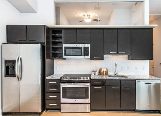 Kitchen with granite countertops and stainless steel appliances at Lex and Leo at Waterfront Station, Washington, DC 20009