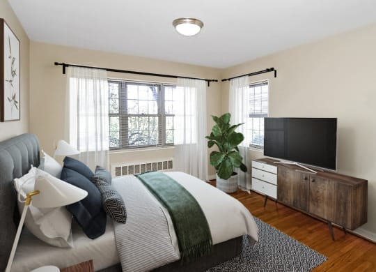 A bedroom with a bed and a tv at Mason Hall in Alexandria, VA 22314