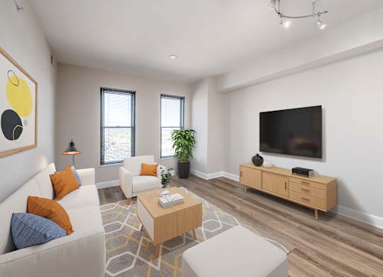 A living room with a white couch, a wooden coffee table, and a flat screen TV mounted on the wall.