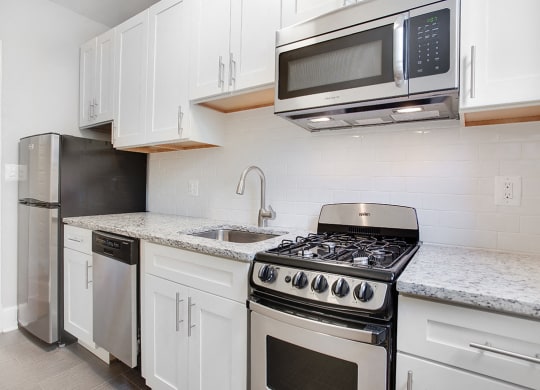 Renovated kitchen with granite countertops and stainless steel appliances at President Madison, Washington
