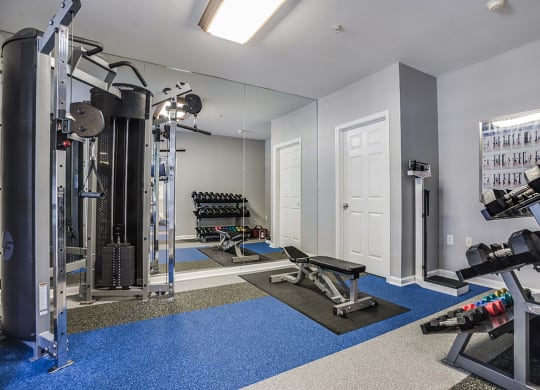 a home gym with a large mirror and exercise equipment at The Residences at King Farm, Rockville, Maryland