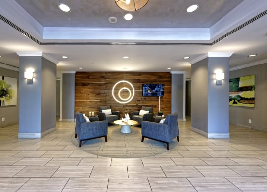 a lobby with couches and chairs and a flat screen tv