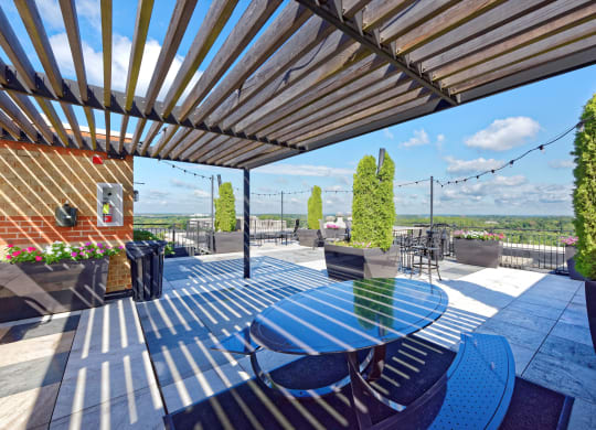an outdoor patio with a blue table and chairs and a view of the city