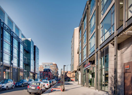 a city street with cars parked on the side of the road and tall buildings on either side at The Shay, Washington, DC 20001