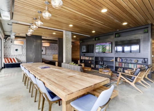 a large wooden table and chairs in a room with a large screen tv on the wall at The Shay, Washington, District of Columbia