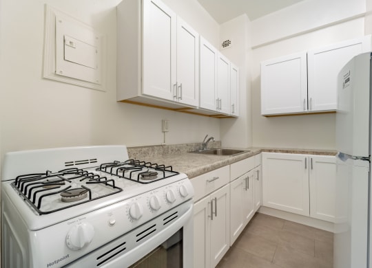 a kitchen with white cabinets and a white stove top oven