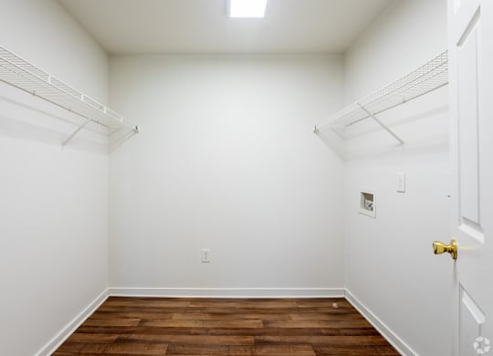 a bedroom with white walls and a wooden floor