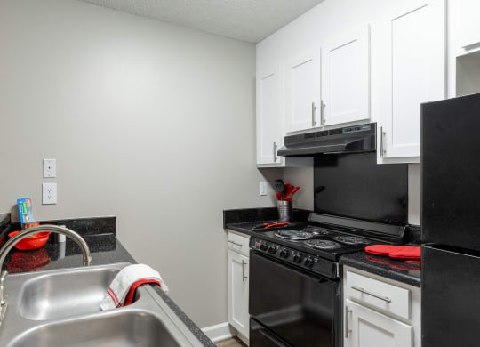 a kitchen with black appliances and white cabinets and a sink