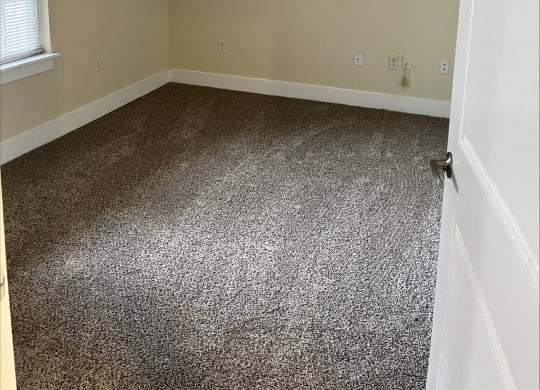 a room with a carpeted floor and a ceiling fan